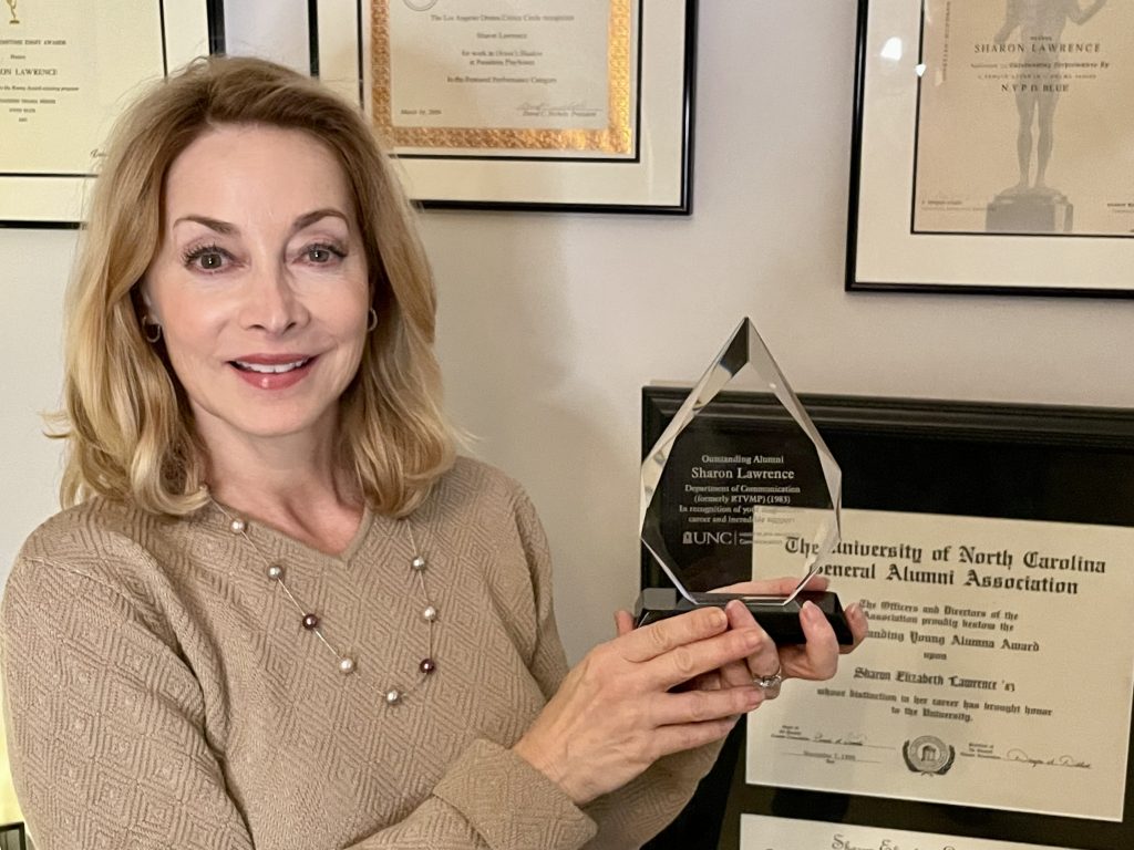 Sharon Lawerence holding her award for Outstanding Alumni